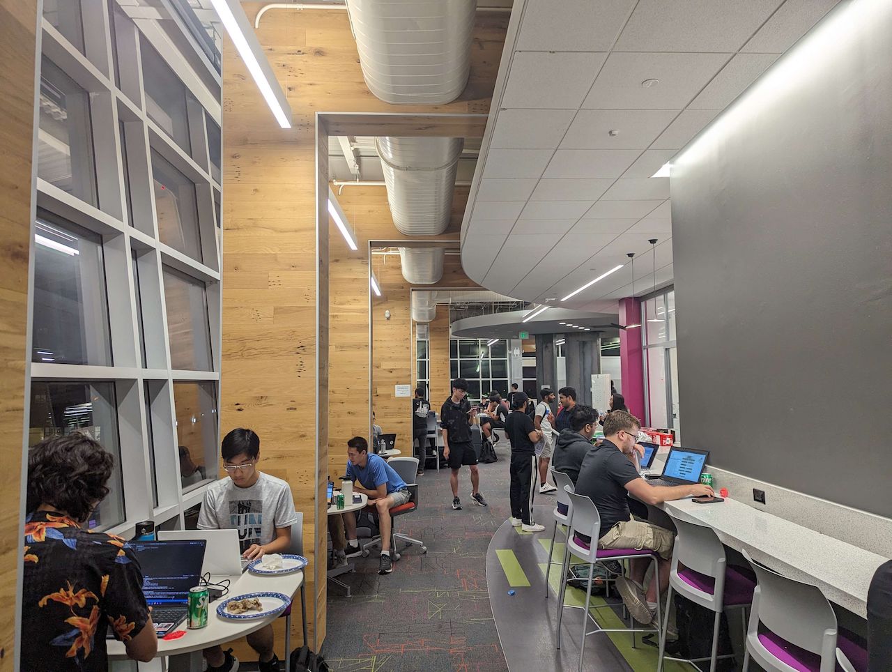 A long shot of a different section of the same makerspace. Every seat is filled with people working.